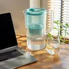 A water filter pitcher and a glass of lemon water on a wooden desk, next to an open laptop, with blinds in the background. Náhľad obrázku produktu