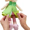 Hands are shown adjusting the skirt of a doll. Voir les images du produit