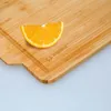 A slice of orange on a bamboo cutting board. Produktbild-Vorschau