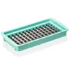 A teal plastic tray with a silver metal grid insert, designed for cutting food into small cubes. Produktbild-Vorschau