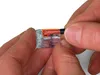 Hands holding a WAGO 221-612 wire connector. Podgląd zdjęcia produktu