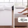 A split image showing a white bed with pillows on the left and a hand stretching a white fitted sheet over a mattress on the right. Produktbild-Vorschau