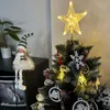 A decorated Christmas tree with a star topper and ornaments, next to a shelf with a decorative elf figure and a plant. Náhľad obrázku produktu