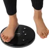 A person's feet are standing on a black twisting disc. Anteprima dell’immagine prodotto