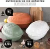 Three ceramic roasters of different colors and sizes are displayed on a wooden surface, with some ingredients like garlic and lemons in the background. Produktbild-Vorschau