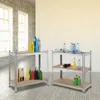 Two metal shelving units are displayed in a room with brick walls and large windows. One shelf holds cleaning supplies, and the other holds bottles. Produktbild-Vorschau
