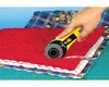 A hand is using a rotary cutter to cut fabric. Produktbild-Vorschau