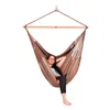 A woman is relaxing in a brown hammock chair. Produktbild-Vorschau
