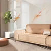 A modern living room with a beige sofa and a plant. Produktbild-Vorschau