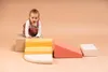 A baby is playing with colorful foam climbing blocks on a plain background. Anteprima dell’immagine prodotto