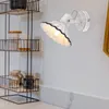 A wall-mounted light fixture is shown next to a shelf unit with jars and containers. Anteprima dell’immagine prodotto