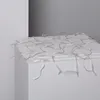 A close-up shot of a string of clear LED lights draped over the edge of a white surface. Produktbild-Vorschau