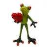 A ceramic figurine of a green frog holding a red heart. Produktbild-Vorschau