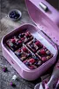 Brownies with berries in a pink tin box on a wooden surface. Anteprima dell’immagine prodotto