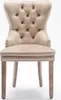 A single beige upholstered dining chair with tufted back and nailhead trim, shown from the front on a white background. Voir les images du produit