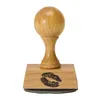 A wooden stamp with a kiss imprint on its base, isolated on a white background. Produktbild-Vorschau