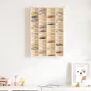 A wooden display shelf filled with miniature toy cars is mounted on a white wall above a white table with wooden toys and a framed picture of a dog. Produktbild-Vorschau
