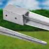 Close-up of a galvanized steel post anchor with a blurred green and blue background. Produktbild-Vorschau