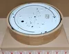 The underside of a round wooden ceiling lamp is shown, resting on a cardboard box. Produktbild-Vorschau