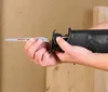 A person is holding a reciprocating saw blade and attaching it to a reciprocating saw. Produktbild-Vorschau