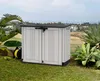 A storage box is placed on a grassy area with plants and a distant view of buildings and the sea. Náhled obrázku produktu
