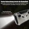 A close-up of a multi-functional emergency radio with a flashlight beam illuminating the foreground. Produktbild-Vorschau