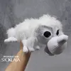 A hand holding a white crocheted toy animal. Podgląd zdjęcia produktu
