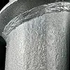 A close-up view of a metal post anchor, showing its textured surface and a welded joint. Náhľad obrázku produktu