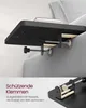 A close-up view of a black bed tray clamped to the side of a bed, with a book on top. A separate inset image shows a detailed view of the clamp mechanism. Produktbild-Vorschau