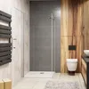 A modern bathroom with a shower cabin, toilet, and a wooden accent wall. Produktbild-Vorschau