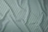 A close-up, top-down view of a crumpled mint-colored satin bedsheet with subtle vertical stripes. Náhled obrázku produktu