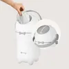 A hand is shown placing a diaper into a white diaper pail. A close-up inset shows the lid mechanism. Produktbild-Vorschau