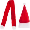 A red Santa hat and a red scarf with white pom-poms are displayed against a white background. Náhled obrázku produktu