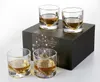 Four whiskey glasses filled with amber liquid are arranged around a black gift box. Produktbild-Vorschau