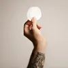 A hand holding two circular white filters. Anteprima dell’immagine prodotto