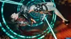A woman in a futuristic outfit is suspended in mid-air against a backdrop of glowing blue rings and orange light. Produktbild-Vorschau