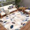 An outdoor patio setting with furniture and a rug.