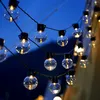A string of globe-shaped lights hanging against a dark blue sky. Náhľad obrázku produktu