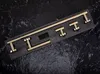 A set of gold bathroom hardware laid out on a dark, textured surface. Produktbild-Vorschau