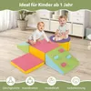 Two babies playing on a colorful foam climbing set in a room with storage units. Produktbild-Vorschau