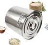 A large stainless steel pot with a lid, surrounded by small bowls of rice and soup, and a sack of rice in the background. Náhled obrázku produktu