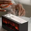 A person is adding essential oil to an aromatherapy diffuser with a fireplace flame effect. Náhľad obrázku produktu