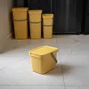 Several yellow plastic buckets with gray handles are arranged on a tiled floor, with one bucket in the foreground and three in the background. Produktbild-Vorschau