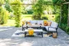 An outdoor patio set with a sectional sofa, bench, and table, set on a paved patio with lush greenery in the background. Produktbild-Vorschau