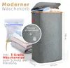 A modern grey laundry basket with a wooden lid, shown with folded laundry and a laundry bag. Podgląd zdjęcia produktu