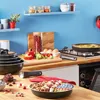 A kitchen counter with cooking ingredients and cookware. Anteprima dell’immagine prodotto