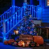 A Halloween-themed porch decoration featuring a decorated Christmas tree with blue lights, pumpkins, and a "Happy Halloween" sign. Produktbild-Vorschau