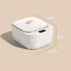 A product shot of a white ultrasonic cleaner with golden trim, showing dimensions. The background is a gradient of beige to white. Produktbild-Vorschau