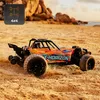 An orange and blue remote-controlled car driving on a sandy beach with rocks and water in the background. Anteprima dell’immagine prodotto