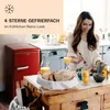 A woman is eating in a kitchen next to a red retro refrigerator. Podgląd zdjęcia produktu